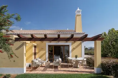 a lighthouse on a house with a table and chairs at 2 bdr Villa with Ocean-View Shared Pool, Luz, Lagos in Luz