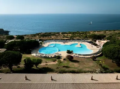 an outdoor patio with a white table and chairs at 2 bdr Villa with Ocean-View Shared Pool, Luz, Lagos in Luz
