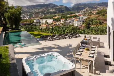 a hot tub on a patio with a table and chairs at Garden Villa by An Island Apart in Funchal