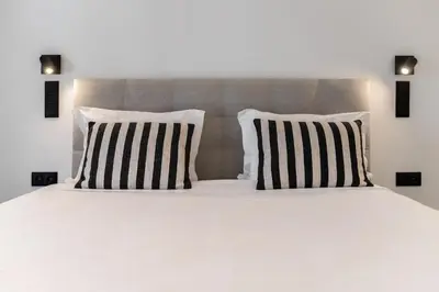 a bed with black and white pillows on it at Garden Villa by An Island Apart in Funchal