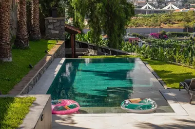 a swimming pool with two inflatable tubes in a yard at Garden Villa by An Island Apart in Funchal