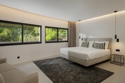 a bedroom with a bed and a couch and windows at Garden Villa by An Island Apart in Funchal