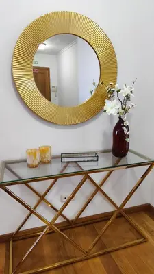 a glass table with a mirror and a vase with flowers at Stay In Funchal- Alto da Pena Apartment in Funchal