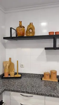 a kitchen counter with two shelves with pots and bowls at Stay In Funchal- Alto da Pena Apartment in Funchal