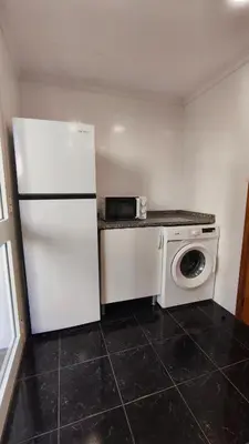 a kitchen with a white refrigerator and a washing machine at Stay In Funchal- Alto da Pena Apartment in Funchal