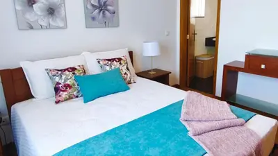 a bed with pillows and a chair in a room at Stay In Funchal- Alto da Pena Apartment in Funchal