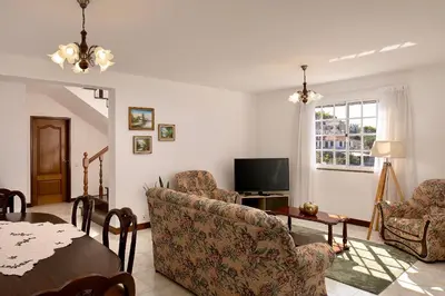 a living room with a table and chairs and a tv at Taste of the Sea by Formosa in Funchal