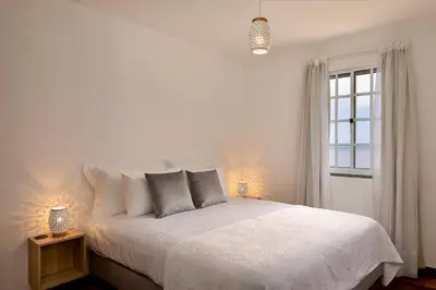 a bedroom with a white bed and a window at Taste of the Sea by Formosa in Funchal