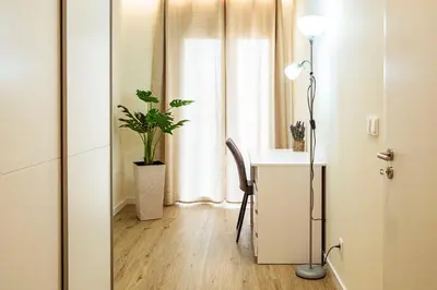 a room with a desk and a table with a lamp at Hidden Corner by Sabugo House in Ponta do Sol
