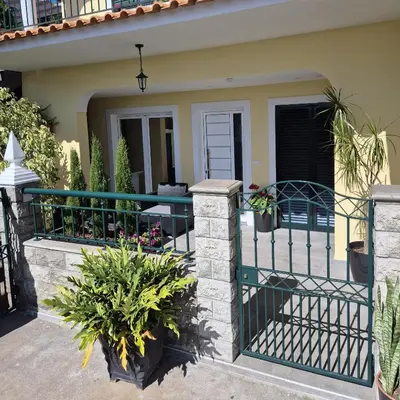a house with a green fence and some plants at Hidden Corner by Sabugo House in Ponta do Sol