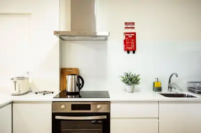 a kitchen with a stove top oven next to a sink at Hidden Corner by Sabugo House in Ponta do Sol
