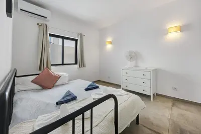 a bedroom with a bed and a desk with a laptop at Villa Vista Azul - Praia Da Luz in Luz