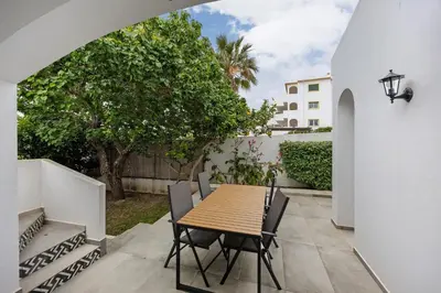a white dresser and a palm tree next to a dresser at Villa Vista Azul - Praia Da Luz in Luz