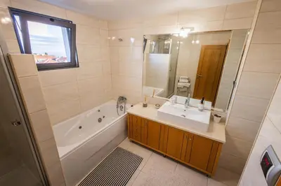 a bathroom with a tub and a sink and a mirror at Madalenas Sun&Sea in Funchal