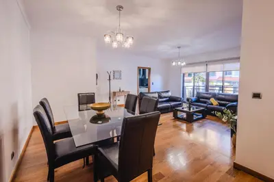 a dining room and living room with a table and chairs at Madalenas Sun&Sea in Funchal