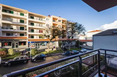 a city street with cars parked in front of a building at Madalenas Sun&Sea in Funchal