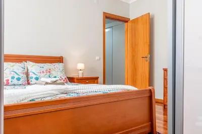 a bedroom with a wooden bed and a mirror at Lobos Village in Câmara de Lobos