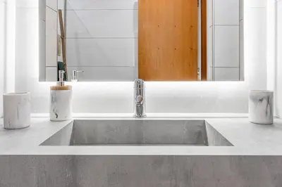 a sink in a bathroom with a mirror and two candles at Lobos Village in Câmara de Lobos