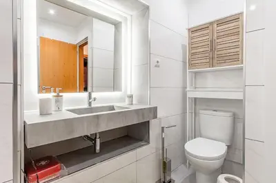 a white bathroom with a sink and a toilet at Lobos Village in Câmara de Lobos
