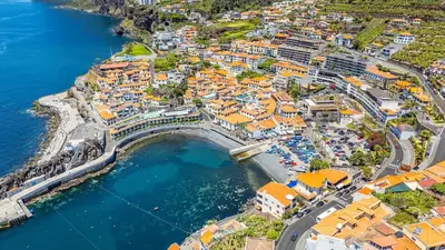 an aerial view of a town next to the water at Lobos Village in Câmara de Lobos