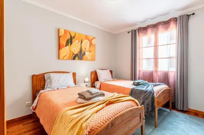 two beds in a room with a window at Lobos Village in Câmara de Lobos