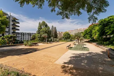 a park with benches and trees and buildings at Apartamento da Silva by An Island Apart in Funchal