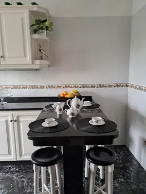 a kitchen with a black table with stools in it at Casa Sequeira in Fajã da Ovelha