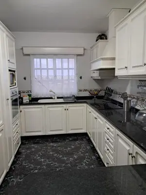 a white kitchen with white cabinets and a window at Casa Sequeira in Fajã da Ovelha