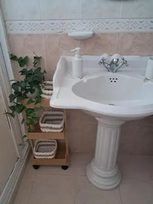 a white sink in a bathroom with a plant at Casa Sequeira in Fajã da Ovelha