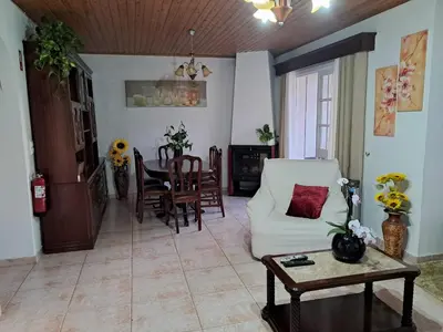 a living room with a white couch and a table at Casa Sequeira in Fajã da Ovelha