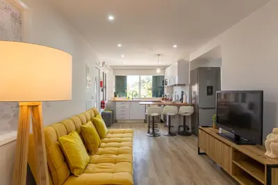 a living room with a yellow couch and a television at Abreu's Place in Câmara de Lobos