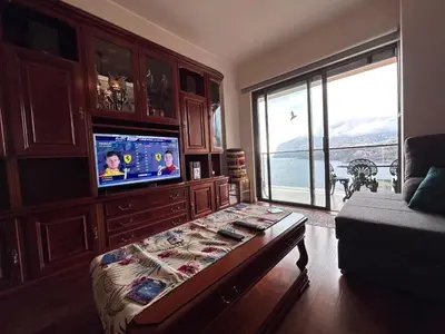 a living room with a tv and a couch at Sunset Ocean View Apartment in Funchal