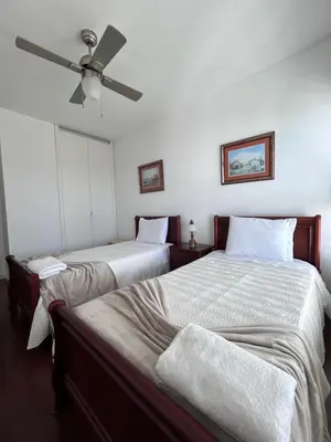 a bedroom with two beds and a ceiling fan at Sunset Ocean View Apartment in Funchal