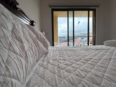 a bedroom with a bed with a view of a city at Sunset Ocean View Apartment in Funchal