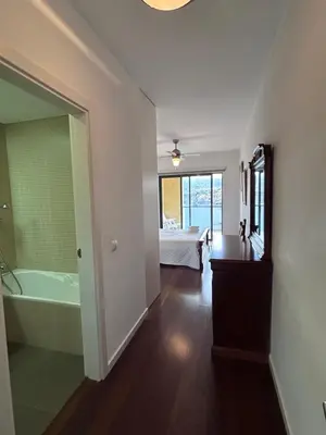 a bathroom with a tub and a bedroom with a bed at Sunset Ocean View Apartment in Funchal