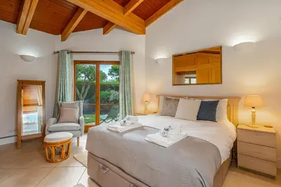 a bedroom with a large bed and a chair at Peaceful and lovely retreat with a pool #1982 in Barão de São Miguel