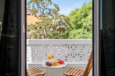 a table with a plate of food and drinks on a balcony at Rumo by KAAMAH in Ribeira Brava