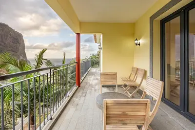 a balcony with chairs and a view of the ocean at Ricardo's Village by YOUR KEY in Porto da Cruz