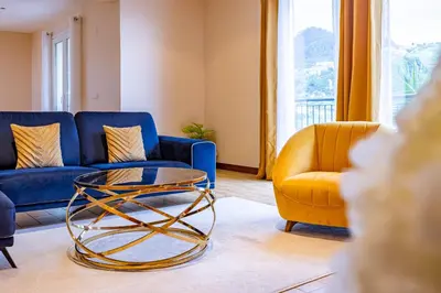 a living room with a blue couch and a glass coffee table at Ricardo's Village by YOUR KEY in Porto da Cruz