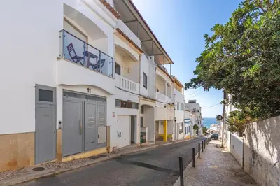 a street view of a white building with grey doors at Aurazul Apartment in Luz