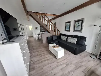 a living room with a black couch and a table at Lovely house on Santa Maria Island Azores in Santa Bárbara