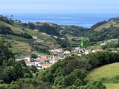 a village in the hills with the ocean in the background at Lovely house on Santa Maria Island Azores in Santa Bárbara