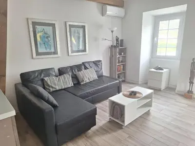 a living room with a black couch and a table at Lovely house on Santa Maria Island Azores in Santa Bárbara