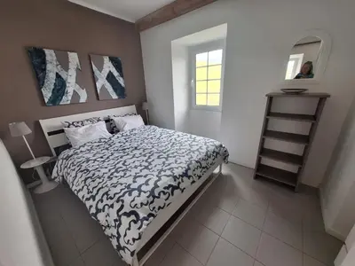 a bedroom with a bed with a blue and white comforter at Lovely house on Santa Maria Island Azores in Santa Bárbara