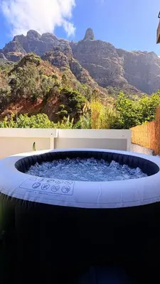 a hot tub with a mountain in the background at Old Aqueduct Village 1 - Guesthouse - Madeira in Serra de Água