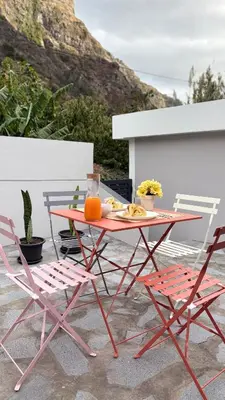 a red table and chairs with a plate of food on it at Old Aqueduct Village 1 - Guesthouse - Madeira in Serra de Água