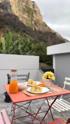 a red table with a plate of food and orange juice at Old Aqueduct Village 1 - Guesthouse - Madeira in Serra de Água