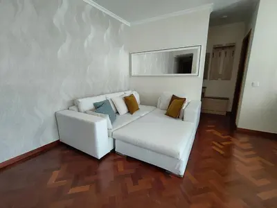 a living room with a white couch and a table at Piornais Views, perto da Praia Formosa in Funchal