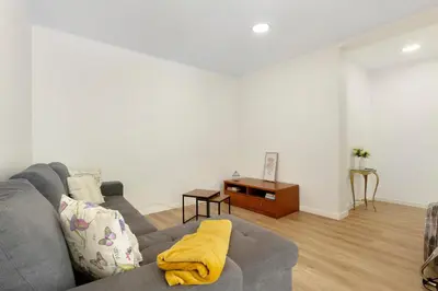 a living room with a gray couch and a table at Moradia Centro Da Cidade Funchal in Funchal
