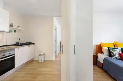 a kitchen and a living room with a couch at Moradia Centro Da Cidade Funchal in Funchal